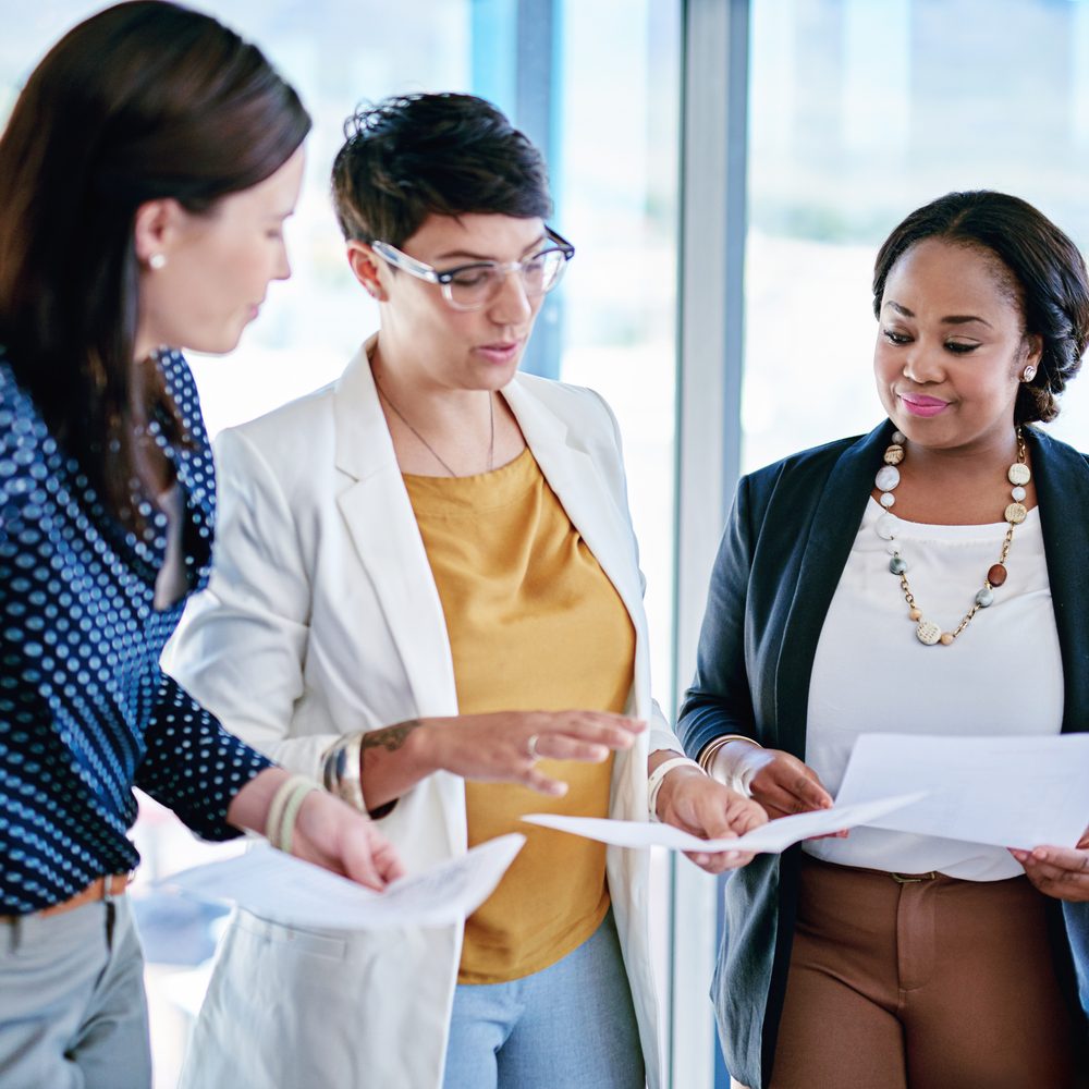 Responsables des ventes analysant une liste de rendez-vous qualifiés autour d’une table.