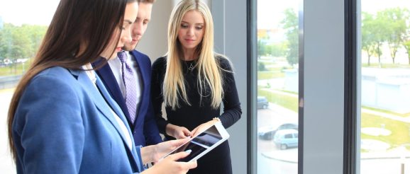 Équipe commerciale examinant un calendrier de rendez-vous de prospection sur un écran.