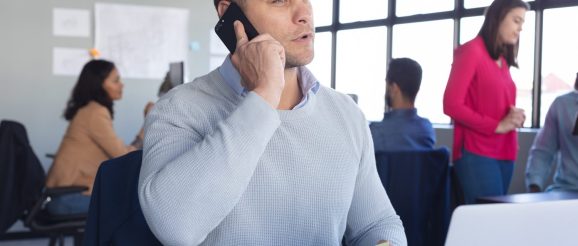 Commercial en formation s’exerçant à vendre par téléphone avec un casque audio.