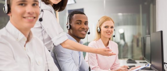 Équipe de téléprospection échangeant au téléphone dans un bureau.