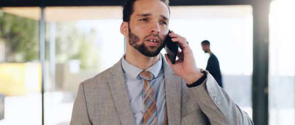 Commercial en téléprospection BtoB, au téléphone avec un décideur depuis son bureau.