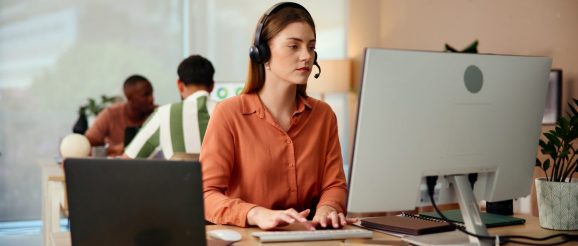 Assistant virtuel freelance travaillant à son bureau avec un ordinateur portable et un carnet de notes.